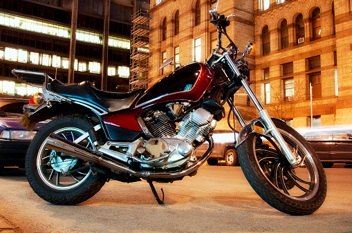 A generic motorcycle against an urban night background with all logos removed and bulding lights exposed enough to hide interior details.