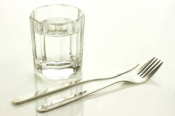 Knife and fork with a glass of water "Glass of water, knife and fork" fast water stock pictures, royalty-free photos & images