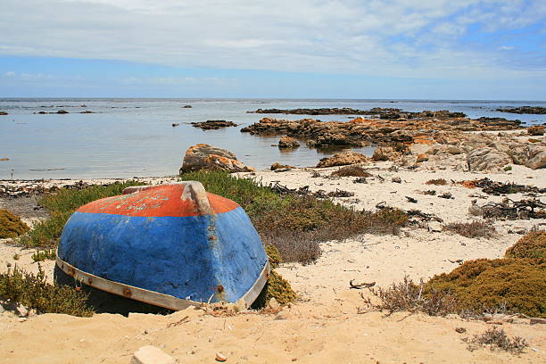 Boat on rocky beach stock photo