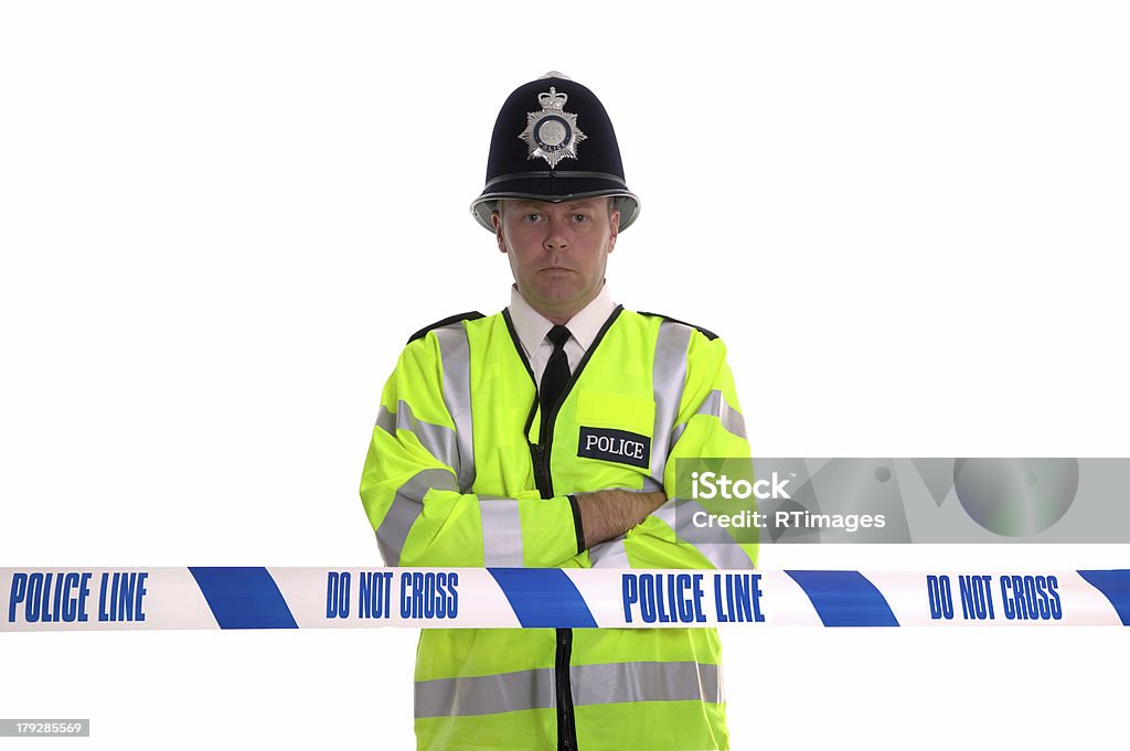 Police Line British Police officer standing behind some cordon tape. Focus is on the tape. UK Stock Photo