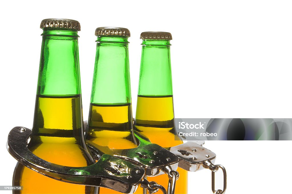 Beer and Handcuffs - Drunk Driving Concept Drunk driving concept - bottled beer and handcuffs. Alcohol - Drink Stock Photo