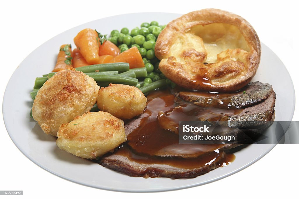 Close up photo of a roast beef, potatoes and veggies dinner Traditional Sunday roast beef dinner with Yorkshire pudding, roast potatoes and vegetables Roast Dinner Stock Photo