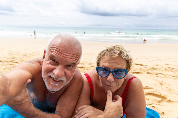 istock Older couple taking a selfie at sunset from the beach 1792876454