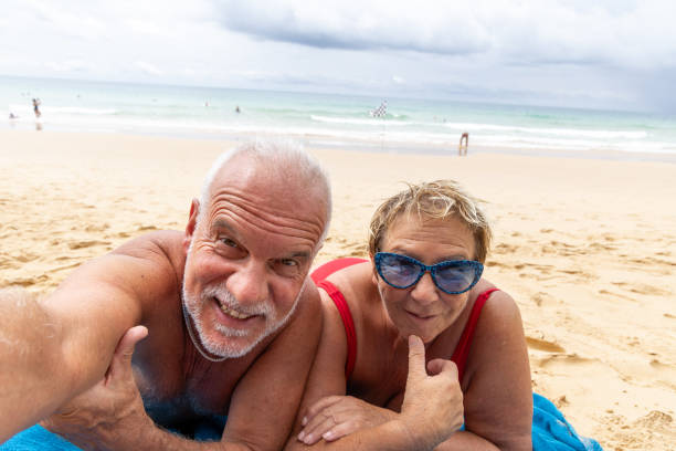 Older couple taking a selfie at sunset from the beach