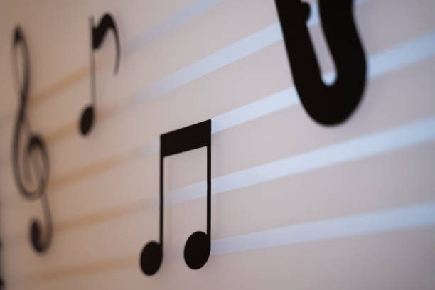 istock Black music notes on a cream wall with shadows in the shade without light 1792881940