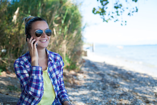 Girl using smartphone on coastline