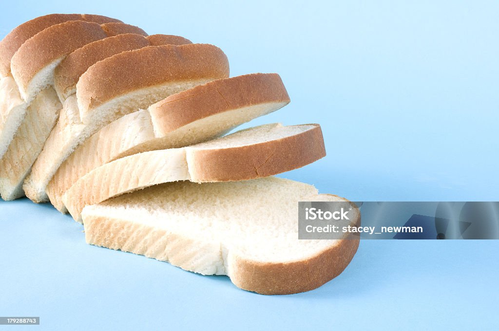 Loaf of sliced white bread on blue background Loaf on white bread on blue. White Bread Stock Photo