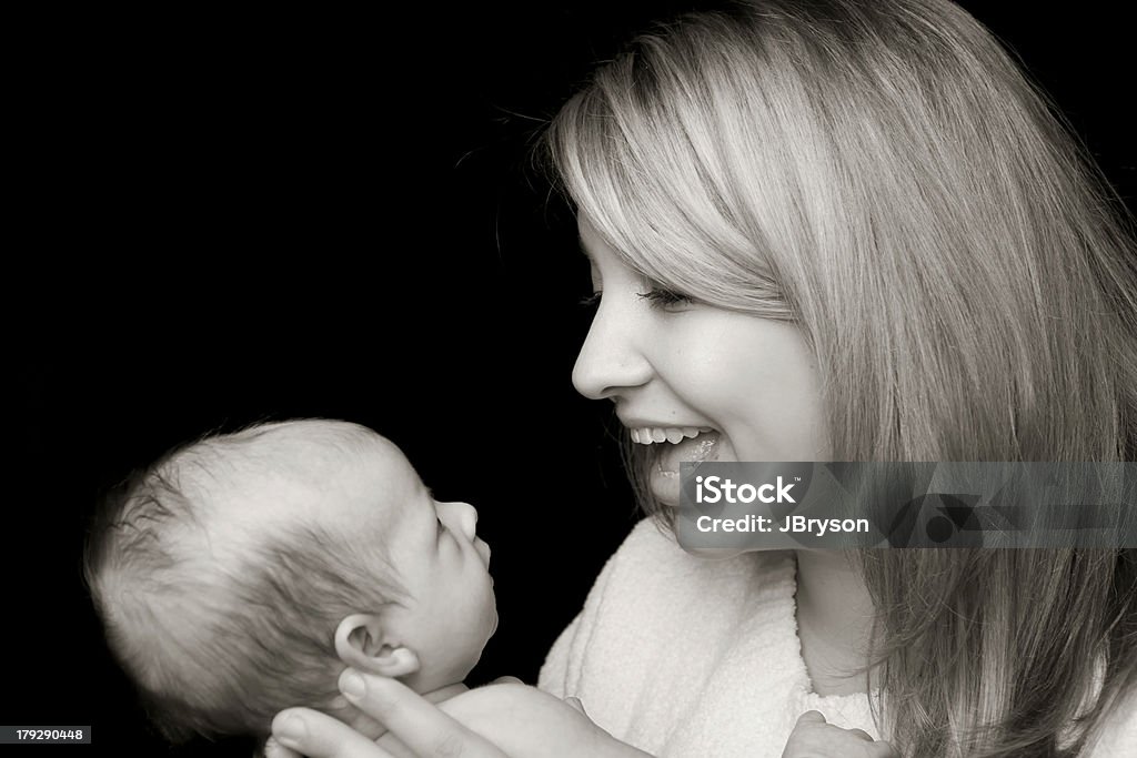 Mother and Baby Communication Young mother talks to her newborn baby. Baby is about 4 weeks old. Adult Stock Photo