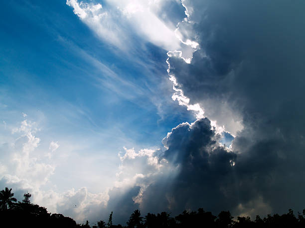 Eternal Struggle Tropical mid morning storm gathering rapidly amidst the bright sun in a clear blue sky angry clouds stock pictures, royalty-free photos & images