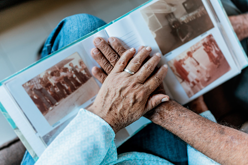 Close-up of couple hands on top of a photo album