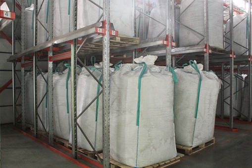 Empty manufacturing factory. Big bag for plastic resin in warehouse. Bags with bulk construction materials standing in storage. Jumbo bags packed with chemical fertilizer, rice and sugar on food plant