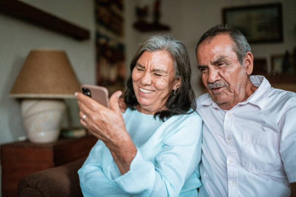Free Stock Photo of Happy couple sitting on sofa using smartphone video ...