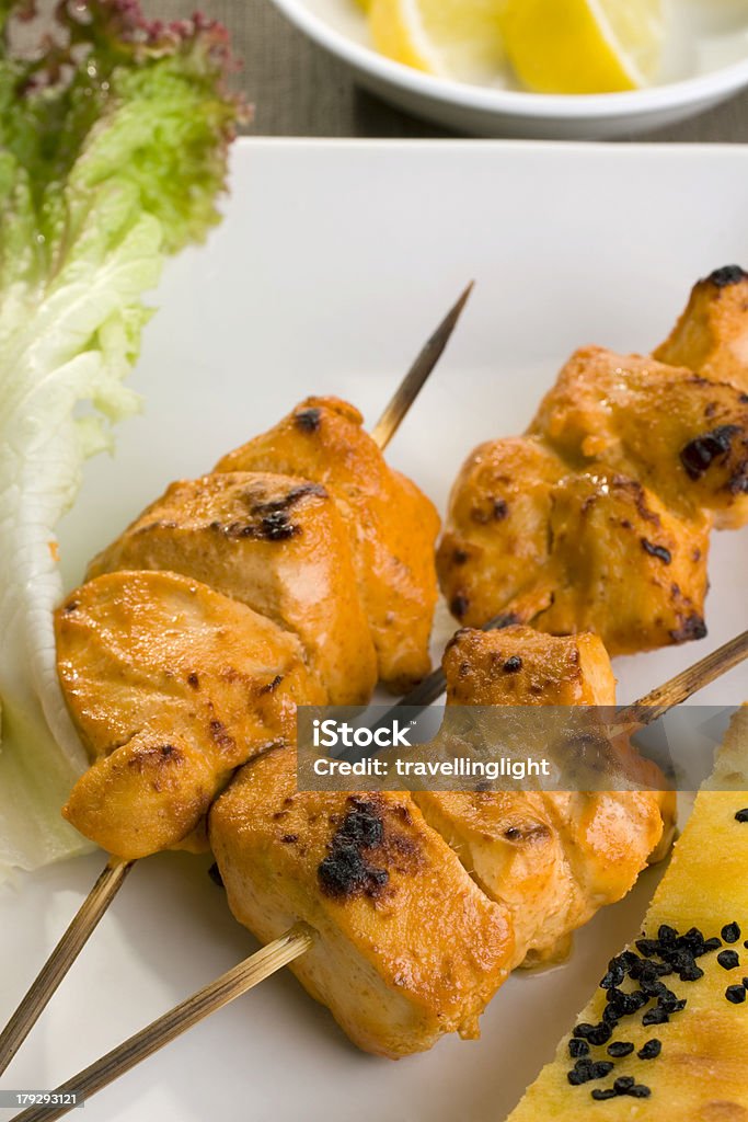 Tandoori Chicken Tandoori chicken on a white plate with lettuce and naan bread. More curry Barbecue - Meal Stock Photo