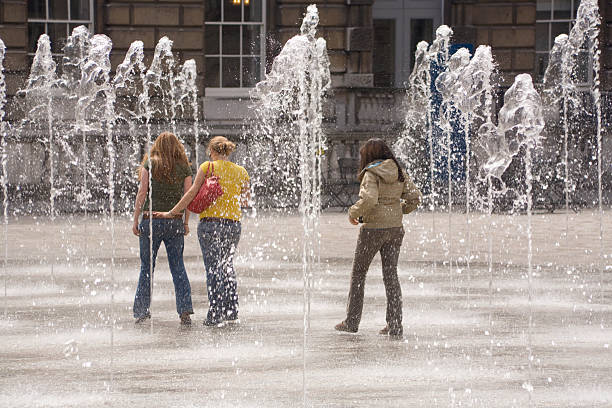 Girls Walking Through Fountain stock photo