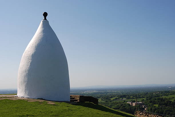Despite the constantly changeable weather, wild flowers and cultivated blooms appear in a multitude of colours to brighten the dramatic landscape of the Somerset Levels and landmarks such as Glastonbury Tor on one of the  steep ridges of the outdoors countryside scenery during summer in Somerset, England, UK