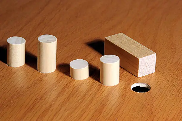 Square peg and a round hole.  Metaphor for a misfit or nonconformist.  See additional images below for other possibilities.