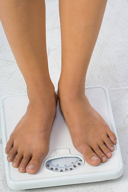 istock Two female feet on a bathroom scale 179294517
