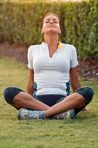 Woman in athletic clothes sitting on the grass stock photo