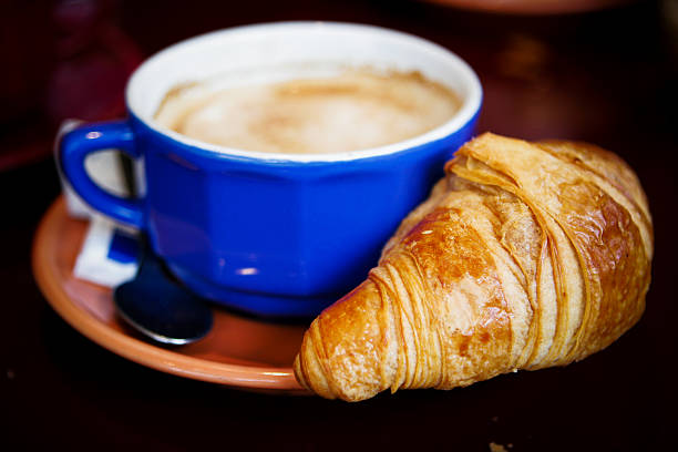 istock Croissant being warmed by blue coffee mug 179294630