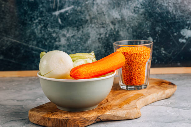 Ingredients for cooking red lentils soup on gray marble background, place for text. Vegan or vegetarian food, clean food concept.
