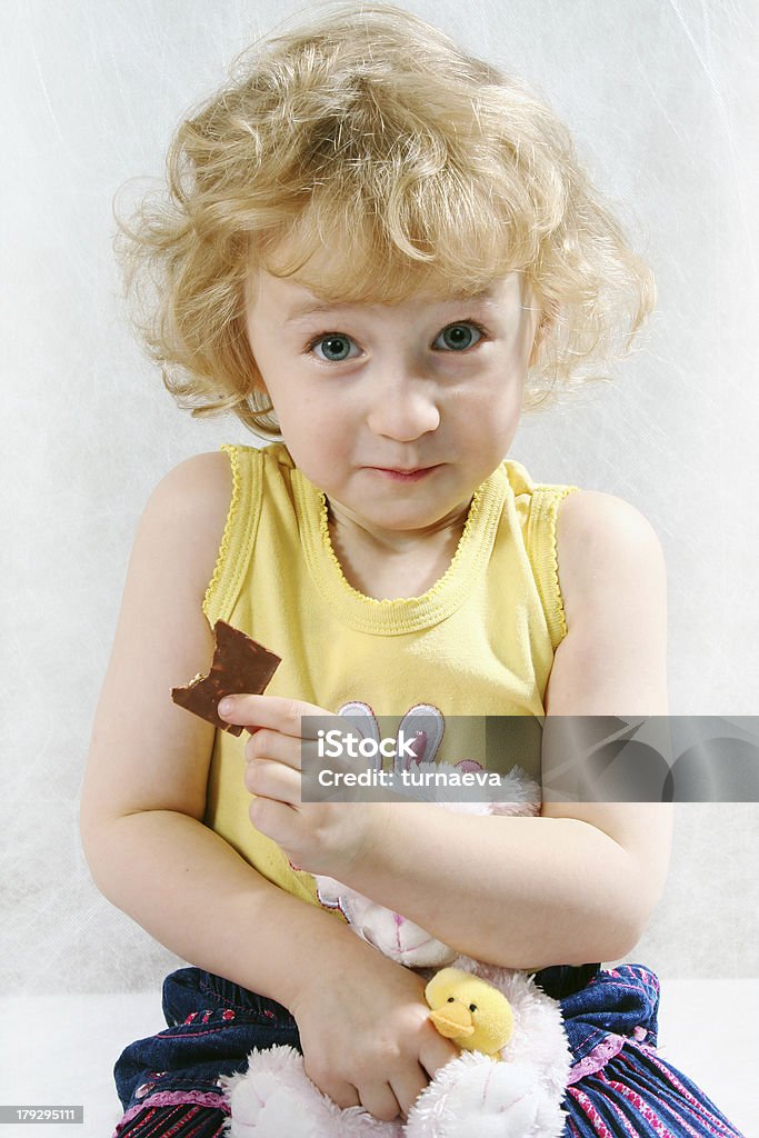 Petite fille blonde Frisée assis sur le blanc avec jouet - Photo de Achards libre de droits