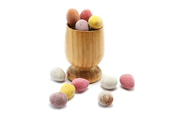 small wooden eggcup with candy coated chocolate easter eggs
