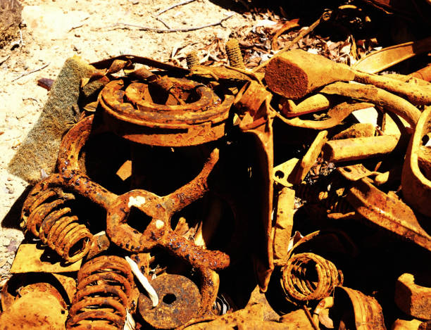 A collection of rusted metal objects, entangled in a disarray of decay, showcases the natural process of oxidation over time, juxtaposing the permanence of metal with the inevitability of corrosion. A tangle of once-functional metal pieces lies in a quiet heap, each item cloaked in the distinctive, textured hues of rust that only time can paint. These remnants, which include coiled springs, weathered gears, and other mechanical parts, tell a silent story of their former utility and the inexorable wear of years. The image captures not just the physical decay but also the beauty in the breakdown, highlighting the contrast between the enduring strength of the metal and its ultimate surrender to nature's patient artistry of oxidation. This scene is a testament to the cycles of use and disuse, an industrial elegy to the things we leave behind.