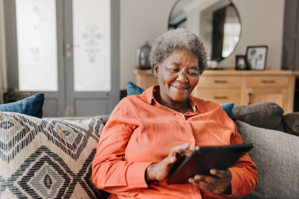 istock Portrait of senior woman using digital tablet on sofa 1792968605