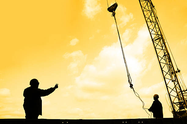 istock Silhouetted construction workers with a crane at sunrise 179296869