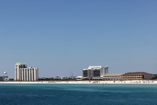 A scenic view of a tranquil beach with several beach homes in the background