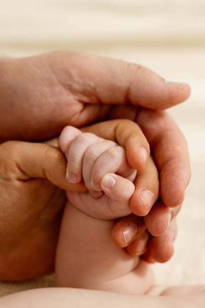 istock Baby's small hand in Mom and Dad's hand 1792980463