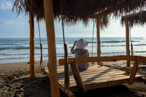 istock Woman in hat on hanging bed on adriatic seashore 1792983204