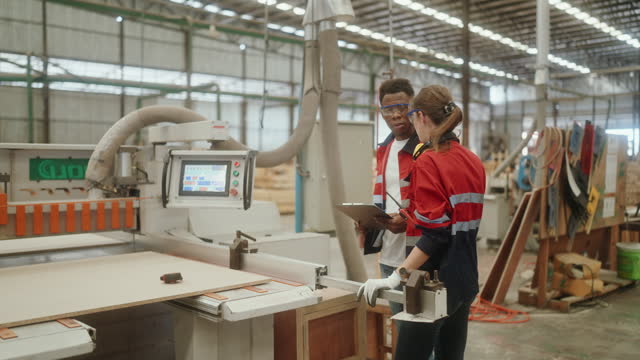 Craftsmanship and Technology Unite: Partners Operating Machinery in Wood Furniture Production at an Industrial Workshop.