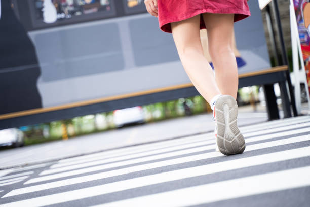 istock A woman walks on a road with a zebra crossing 1792991976