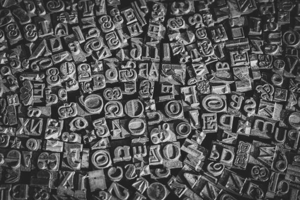 istock A black and white textured background of lead type-setting letter blocks with various fonts, upper- and lowercase, antique letters. 1793001436