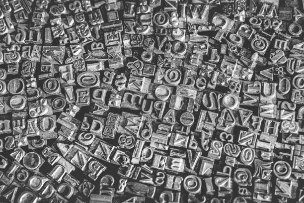istock A black and white textured background of lead type-setting letter blocks with various fonts, upper- and lowercase, antique letters. 1793001609