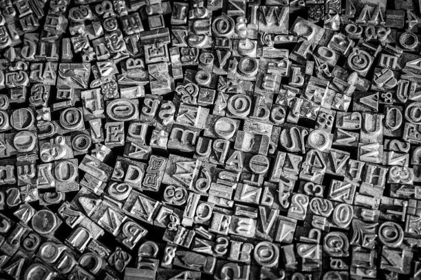 istock A black and white textured background of lead type-setting letter blocks with various fonts, upper- and lowercase, antique letters. 1793001667