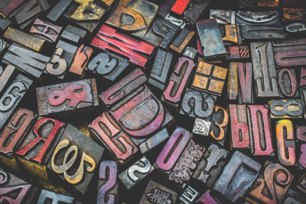 A textured background of old, used, wooden type-setting letter blocks with various fonts, upper- and lowercase, antique letters, all shapes and sizes.