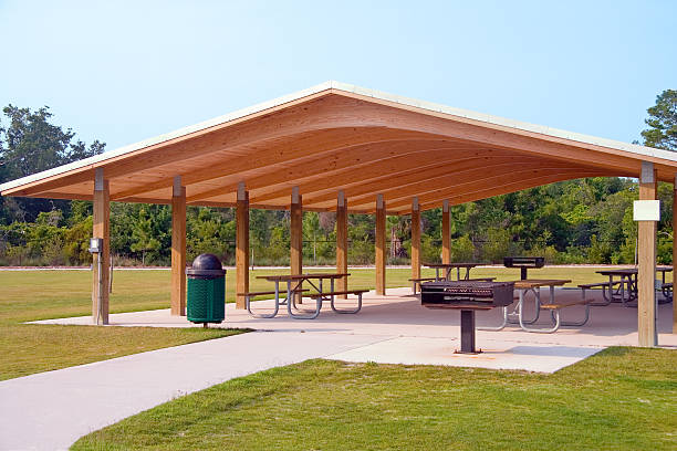Picnic area Picnic tables and grill under wood roof structure in local park pavilion photos stock pictures, royalty-free photos & images