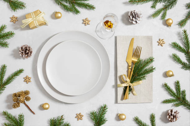 istock Christmas table setting with empty plate, gold cutlery and festive accessories on white background. New Year party. Top view, flat lay. 1793007710