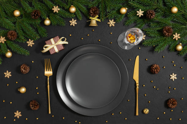 istock Christmas table setting with black empty plate, gold cutlery and festive decor on black background. Preparing for Christmas dinner. Happy new year. Top view, flat lay. 1793008842