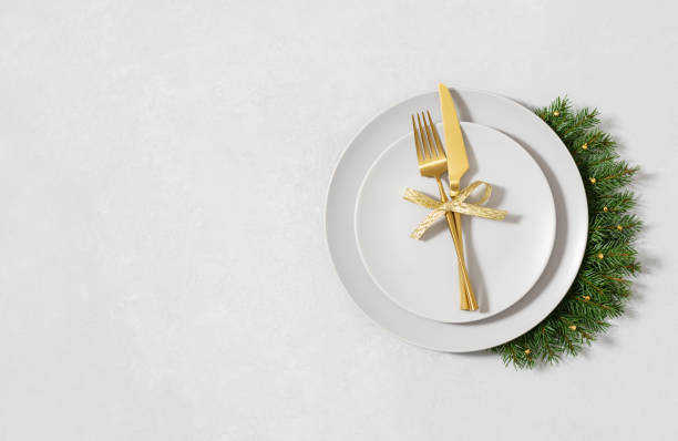 istock Christmas table setting with gold cutlery and fir branches on awhite background with copy space. Happy new year. Space for text. Top view, flat lay. 1793010072