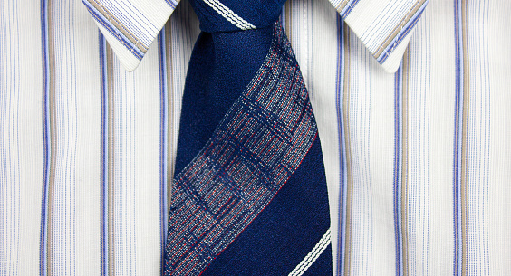 White classic men's striped shirt with blue tie.