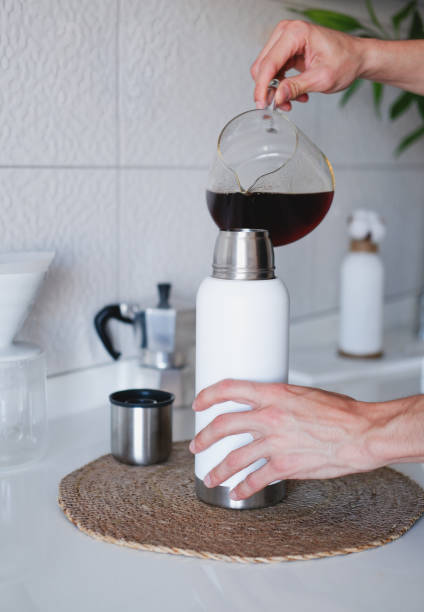 istock Man pouring coffee into thermos at home 1793017937