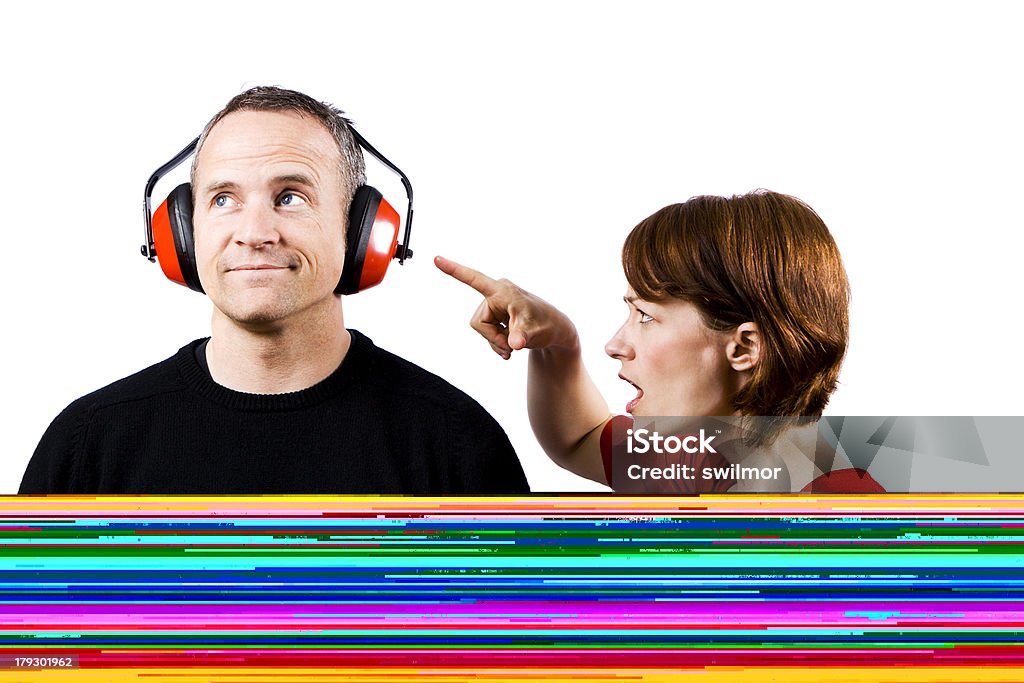 Mujer a Man Yelling uso de protectores auditivos - Foto de stock de Girar los ojos libre de derechos