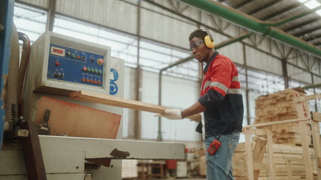 Skilled Woodworker Operating Machinery in the Heart of a Contemporary Furniture Manufacturing Plant.