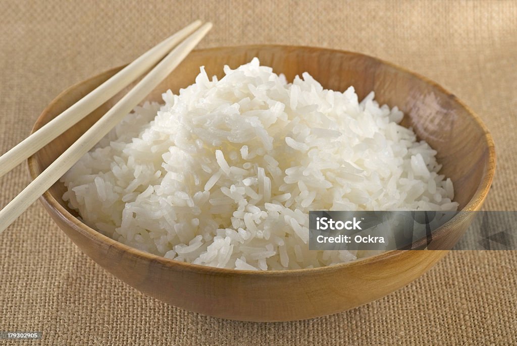 Rice Jasmine rice in a handmade wooden bowl and chopsticks. Burlap Stock Photo