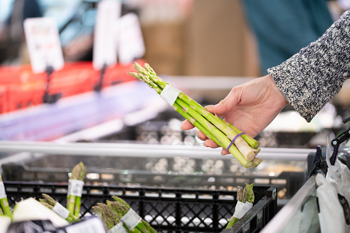 Woman's hand choosing asparagus