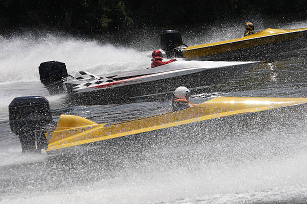 People racing on speed boats in the ocean stock photo