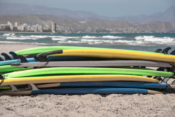 istock Set of different color surf boards in a stack by see. Surf boards for school on sandy beach. Soft toned photo. 1793041168